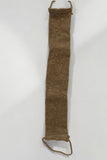 A long, narrow beige knitted object with visible texture, featuring a loop at each end. The Lather and The Wick's All Natural Back Scrubber appears to be made from coarse, natural fiber and is displayed against a plain white background. It's biodegradable and perfect for gentle exfoliating.